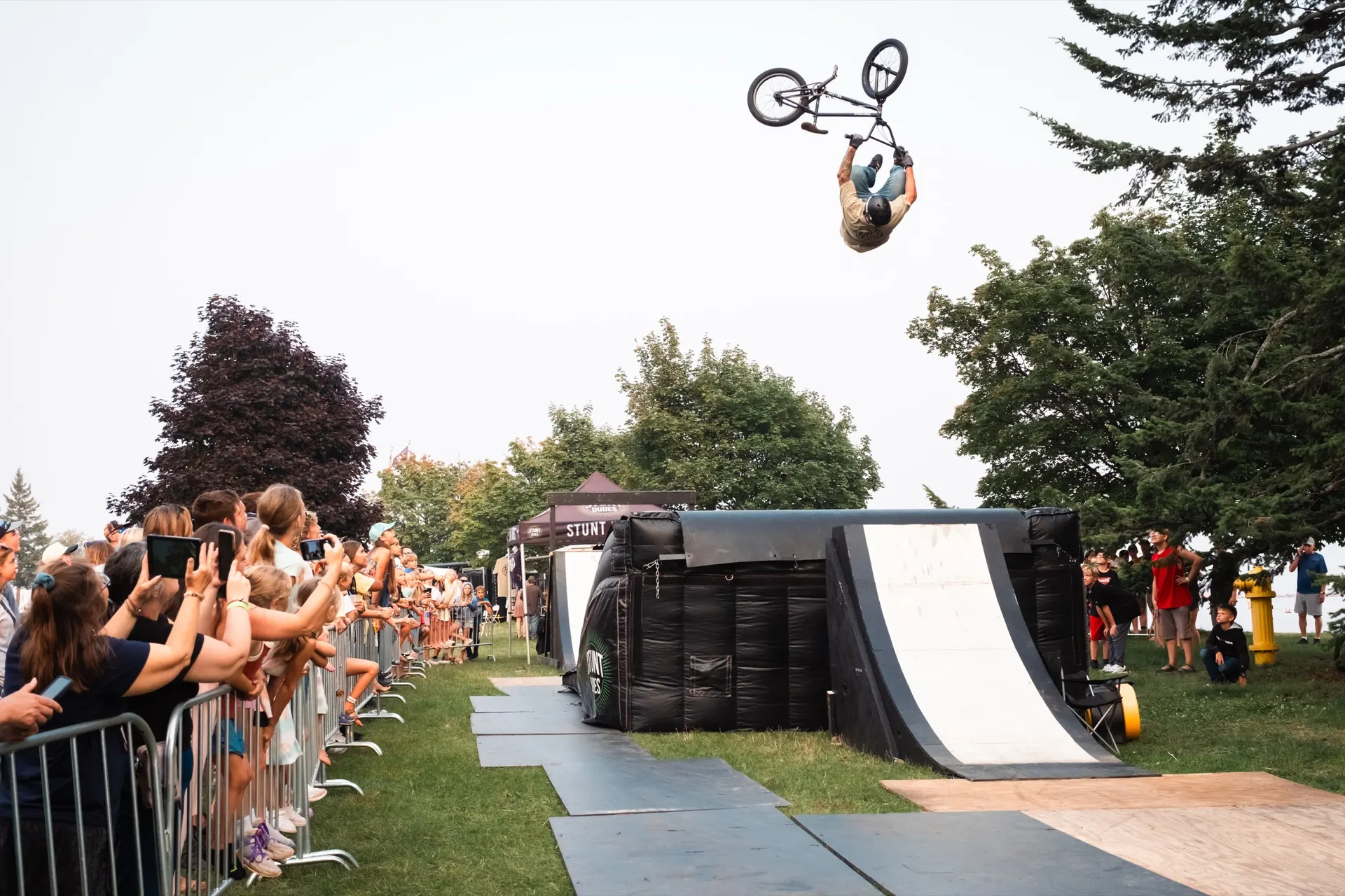 StuntDudes rider inverted above a barrier packed with fans
